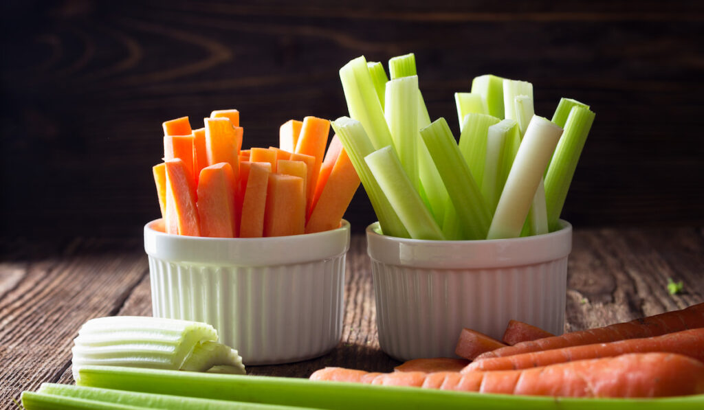 celery and carrot in a cup on wooden table