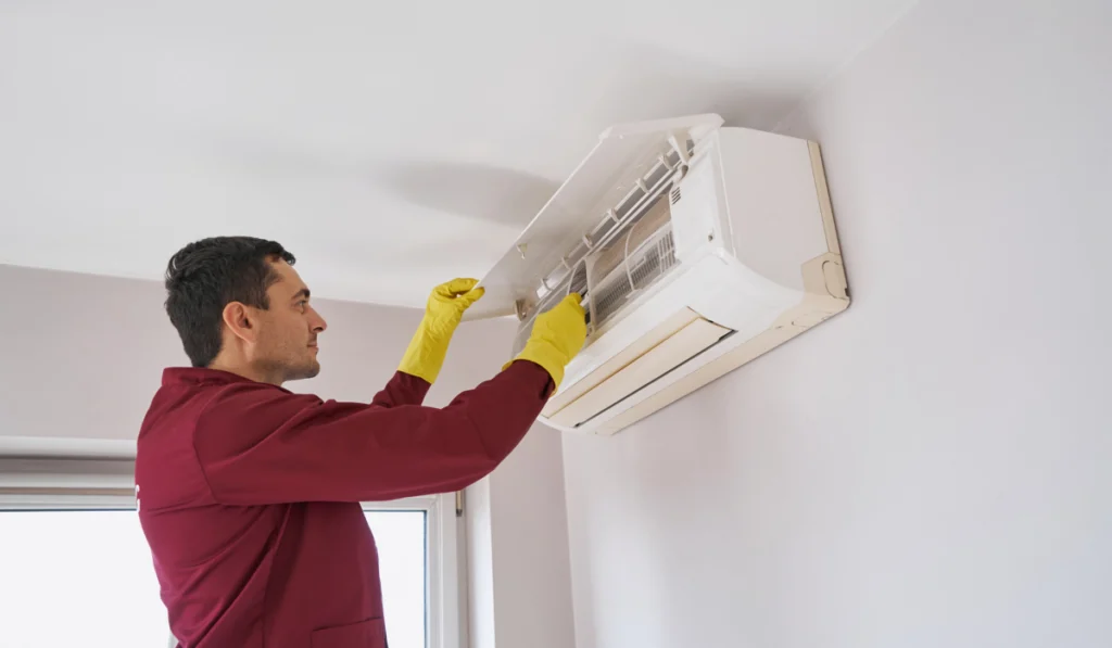 technician guy cleaning air-conditioning unit