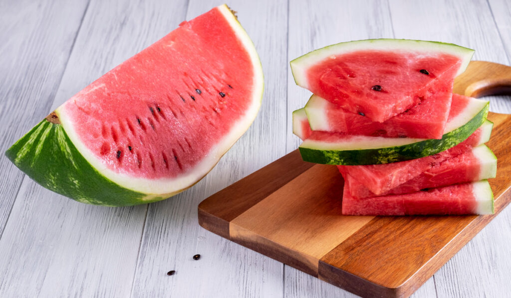 cut and slices of ripe  watermelon on white table 