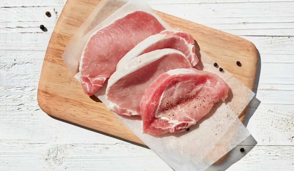 fresh raw pork meat on wooden chopboard