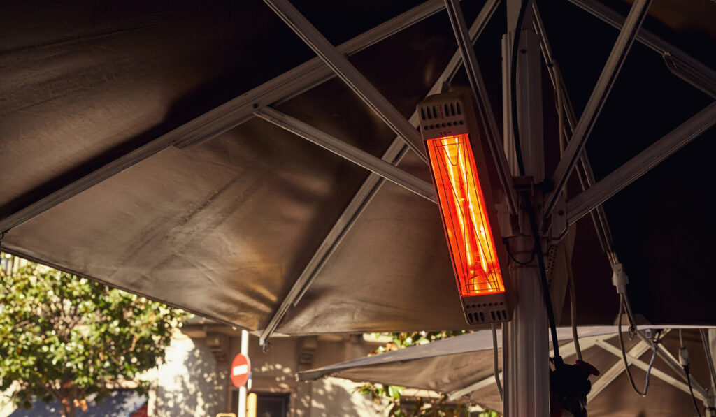 image of street with electric outdoor heater hang on under big umbrella