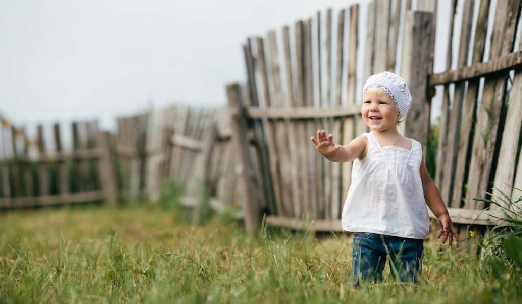 little girl and wooden fence