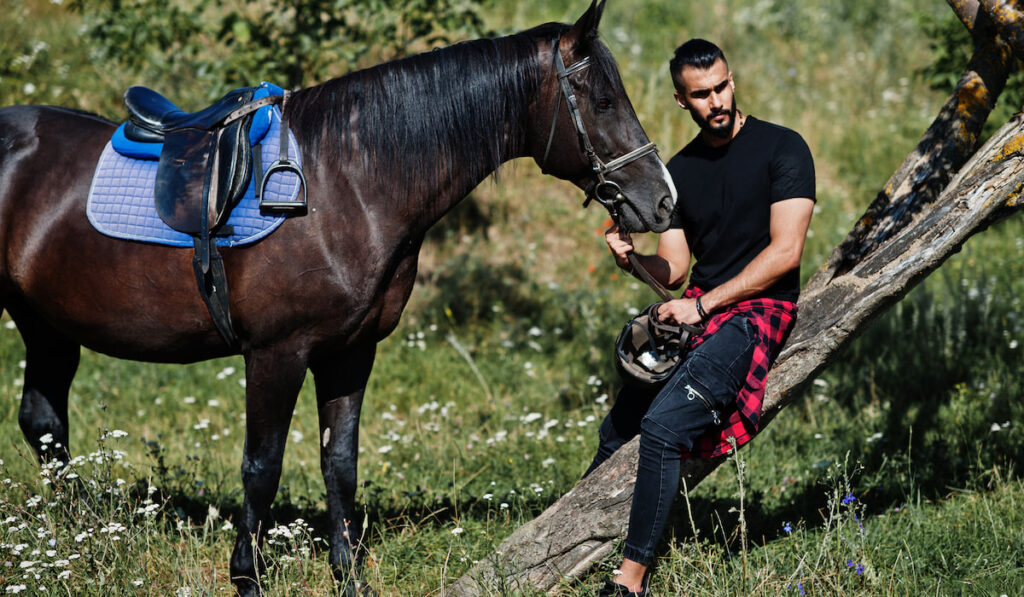 man posing with his arabian horse 