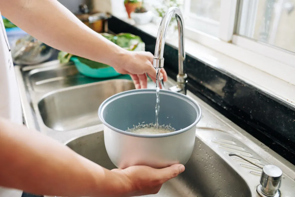 man putting water for cooking rice