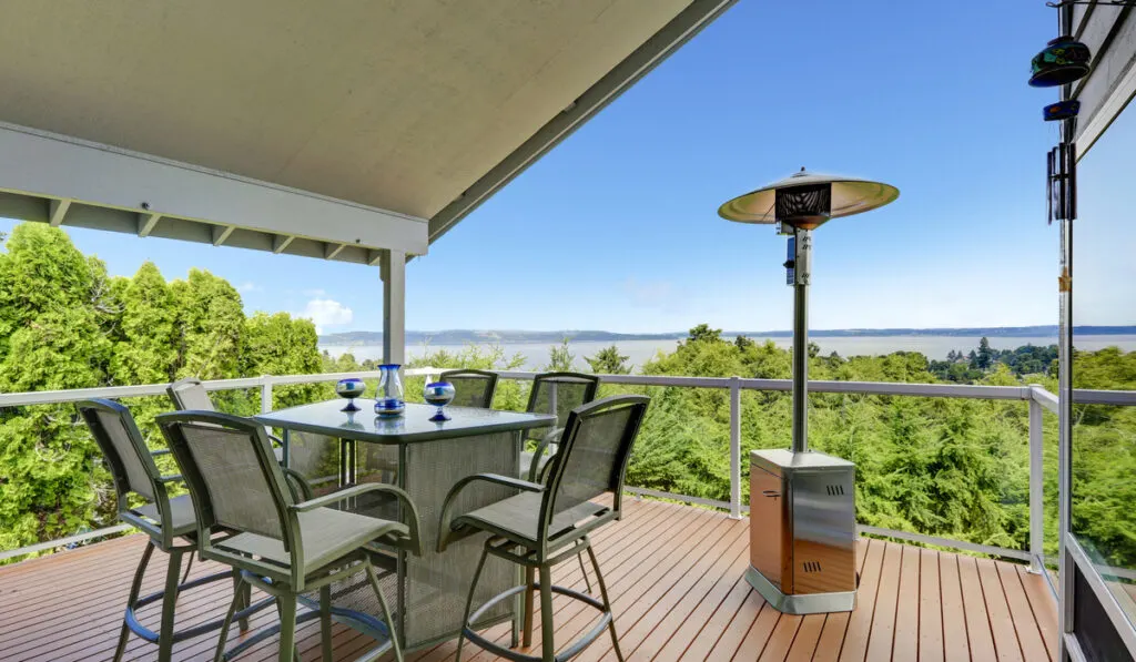 patio area with table and chairs and free standing heater 