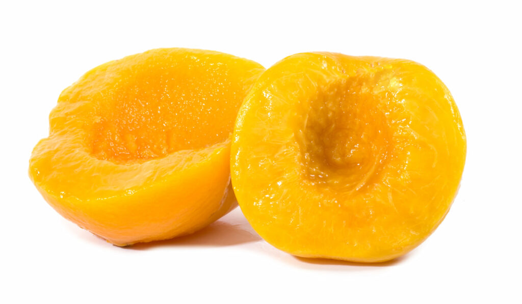 peeled slices of peaches on the table on white background