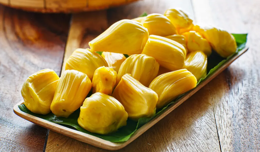 pile of peeled jackfruit on banana leaf serving tray 