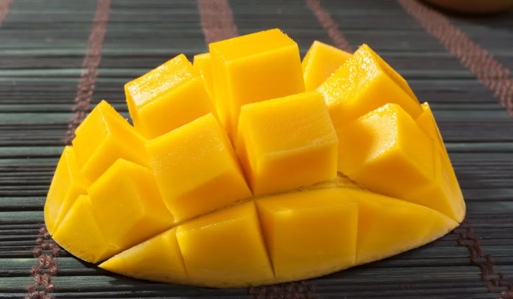 sliced piece of mango on dark table