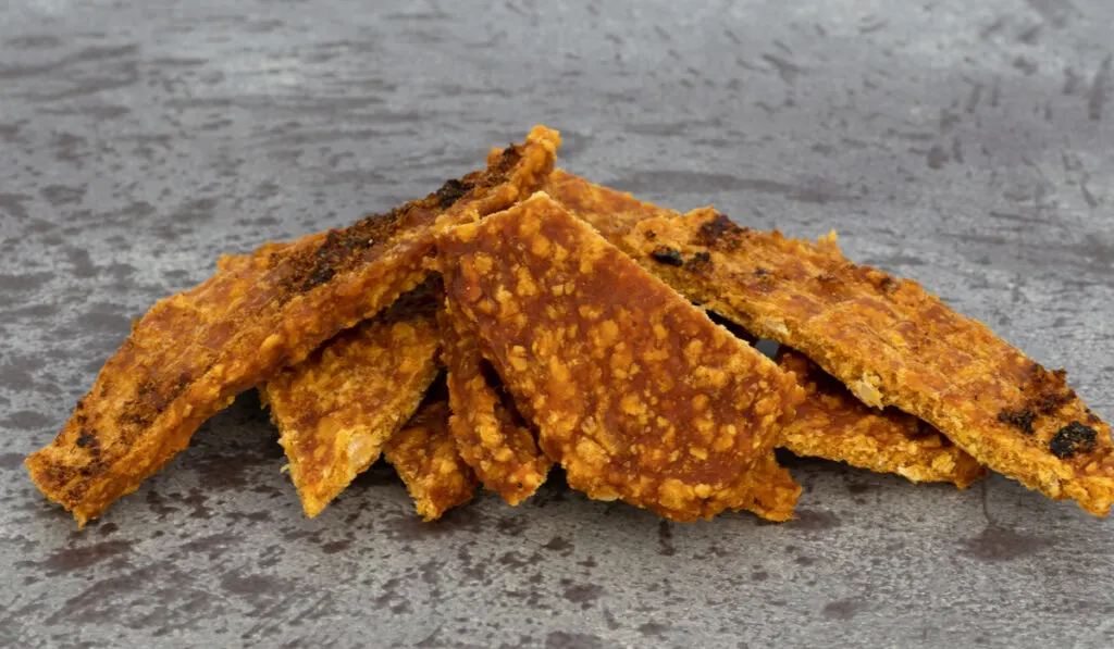 slices of duck jerky on stone background 