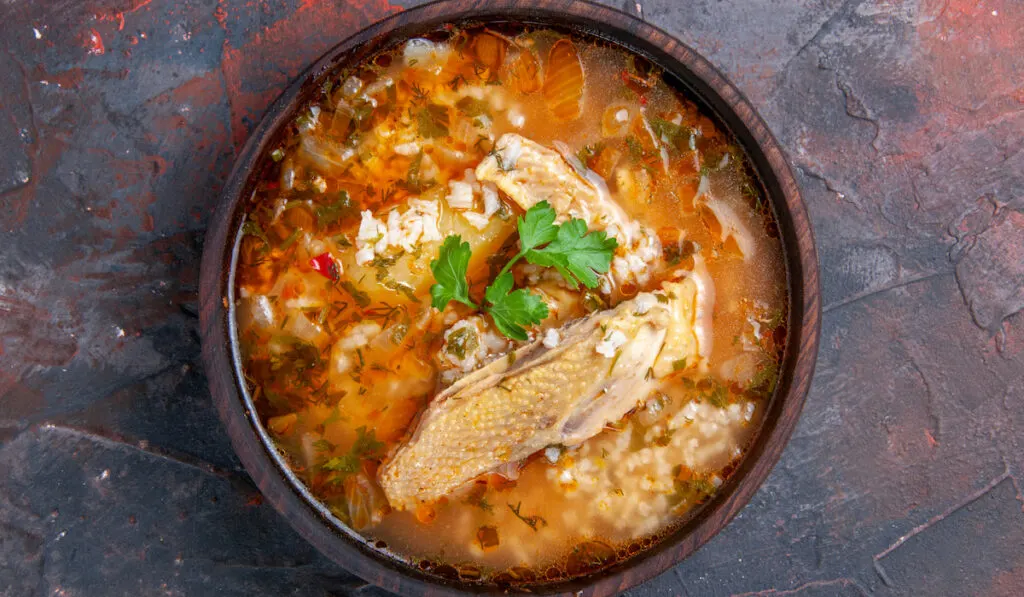 top view homemade chicken and rice soup on dark background