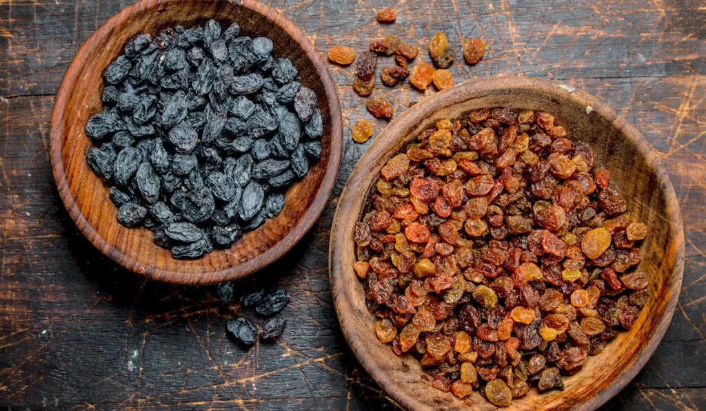 two different color of raisins in wooden bowls