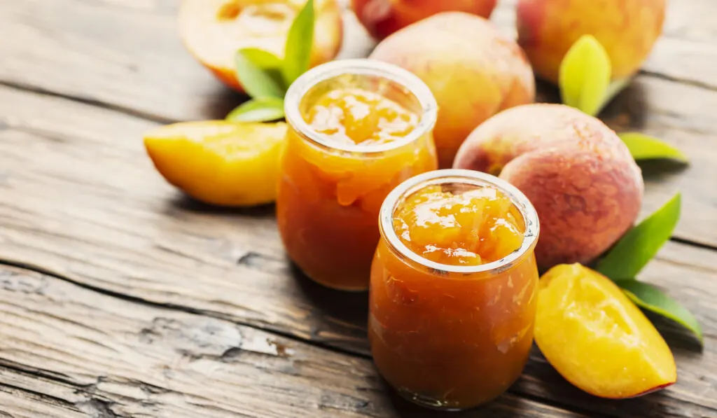 Sweet natural peach jam and peaches on the table