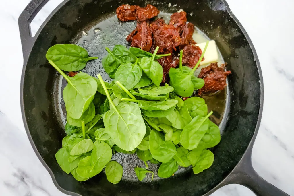 Added Spinach in a cast iron skillet with sautéed sun-dried tomatoes and butter 