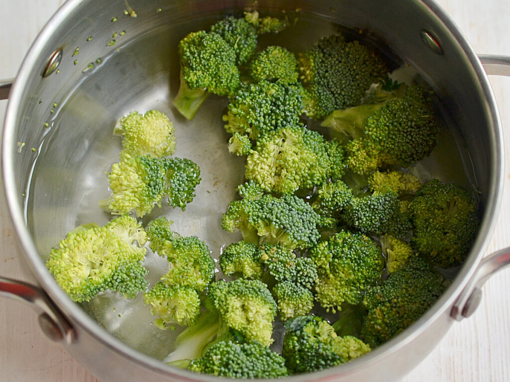 Cut pieces of broccoli soaked in water in an aluminum casserole.