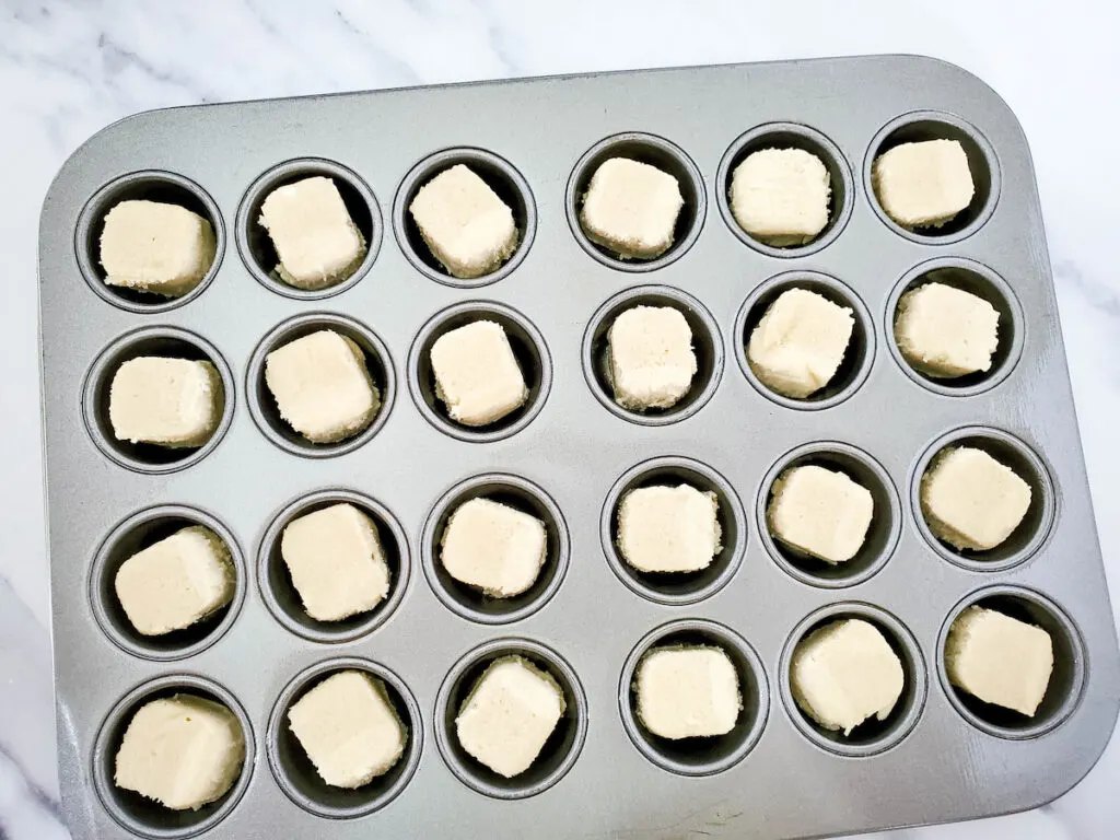 One cookie dough into each muffin tin tray