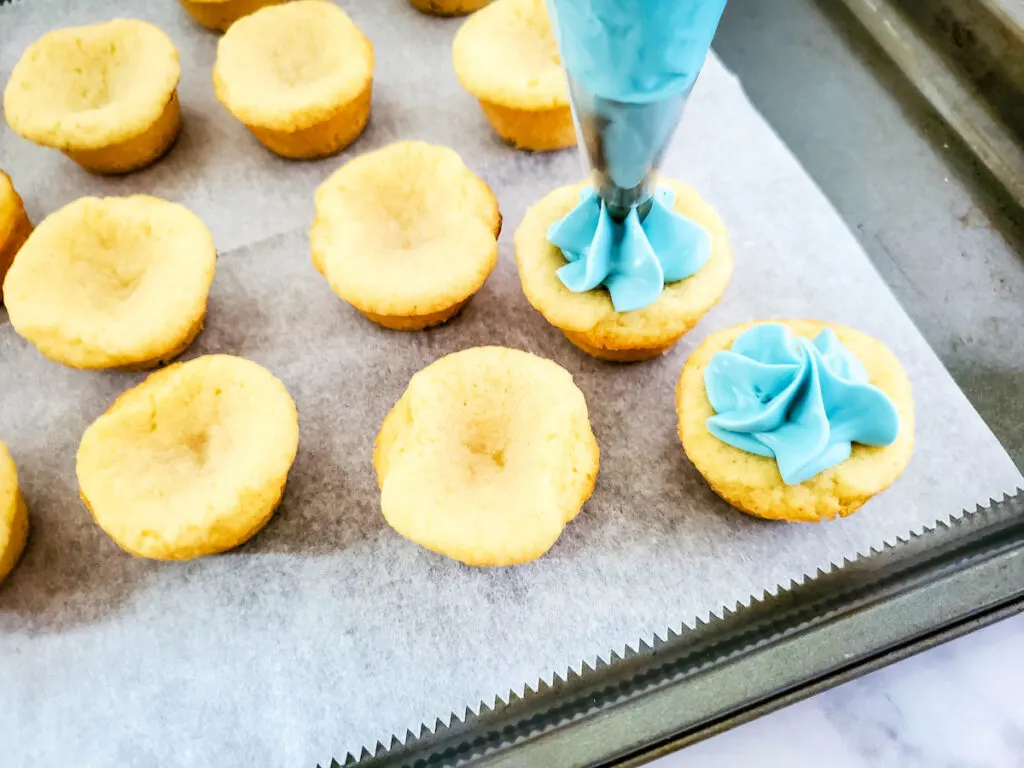 Pipping the frosting on the cookie dough cups