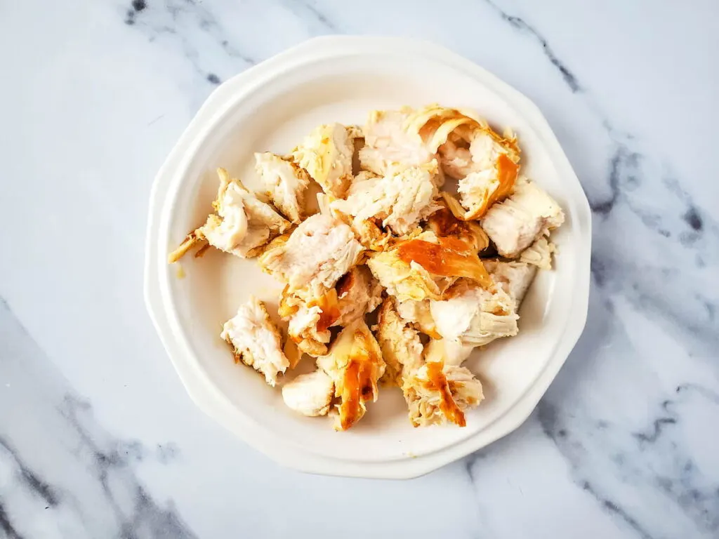 chicken breast cut into cubes on a white plate