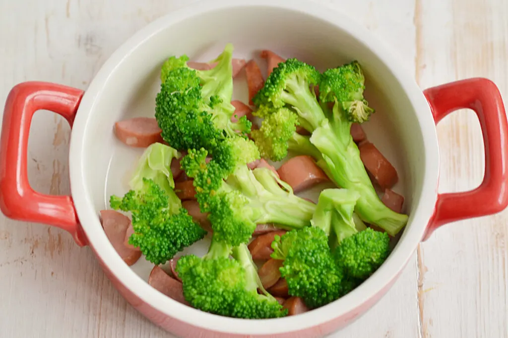 sliced sausages and broccoli in a casserole