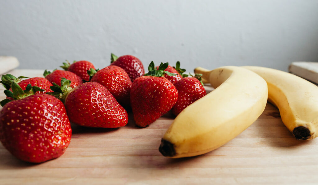 strawberry banana fruits on wood table
