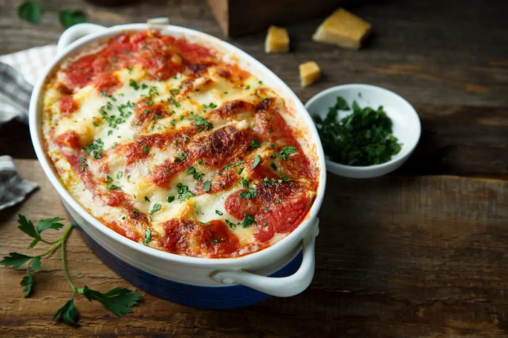 Homemade pasta bake with cheese, pesto and tomato sauce