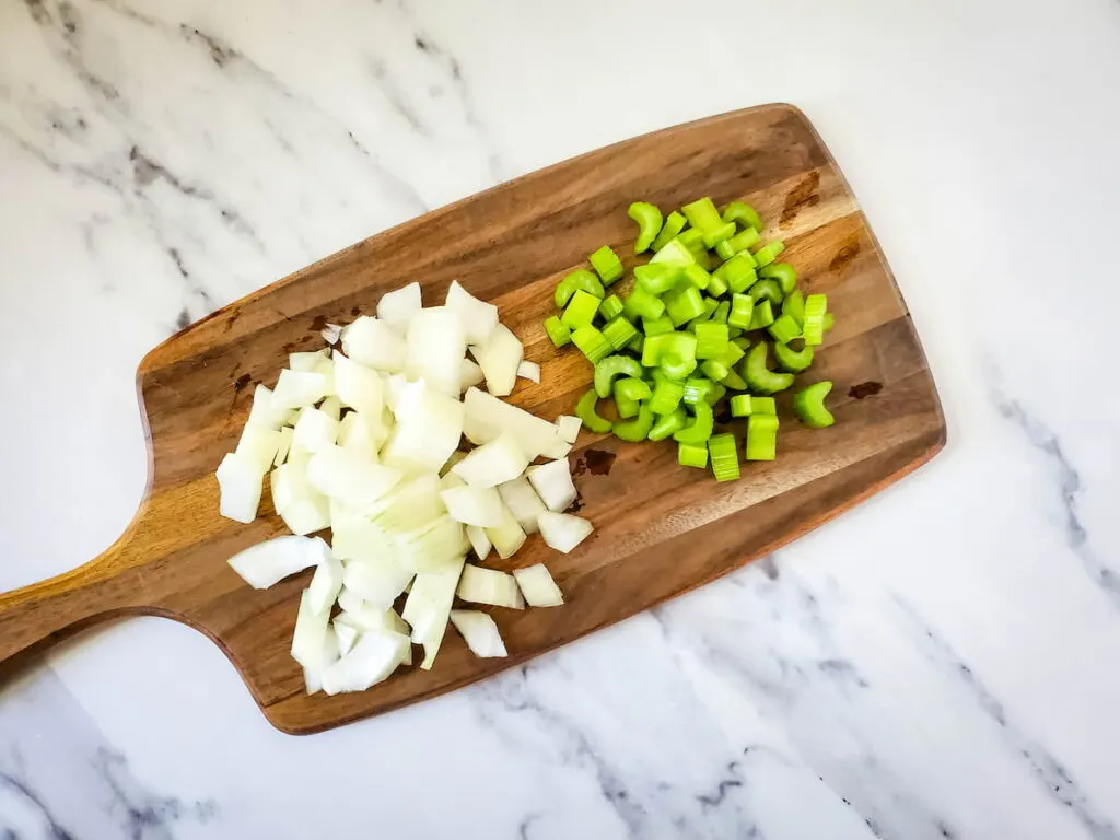 Process 1 - Chopped celery and diced onion on wooden chopping board