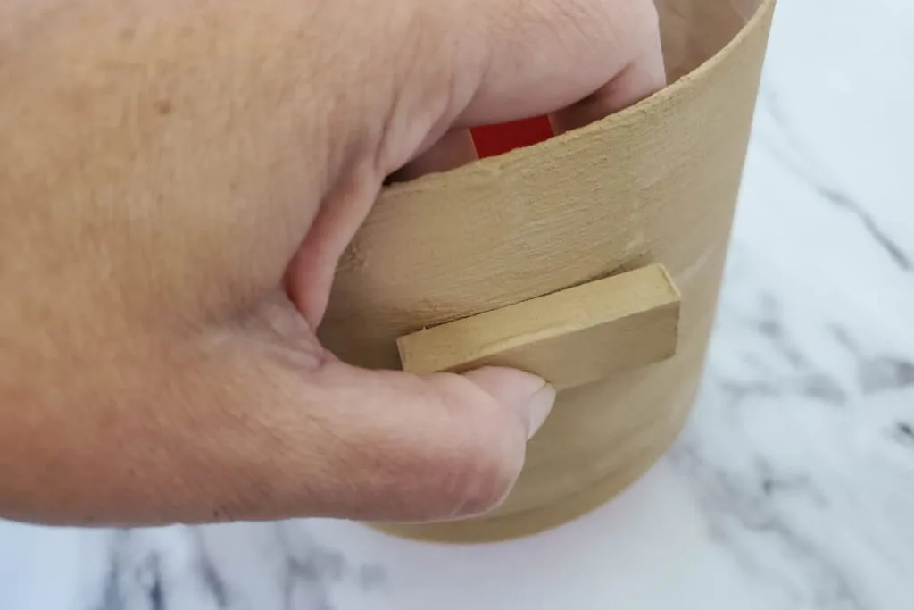 putting the the blocks with the glue to the sides of the pot