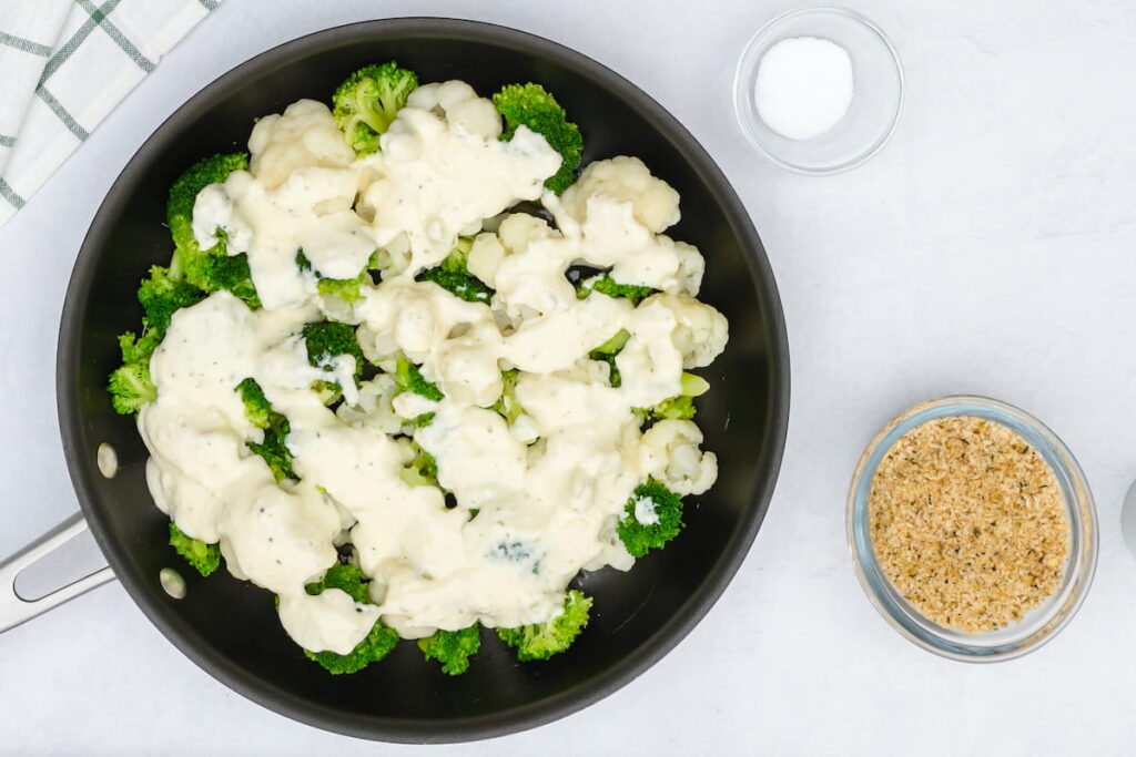 Vegetables, cauliflower and broccoli, with Alfredo sauce and bread crumbs close up on kitchen table 