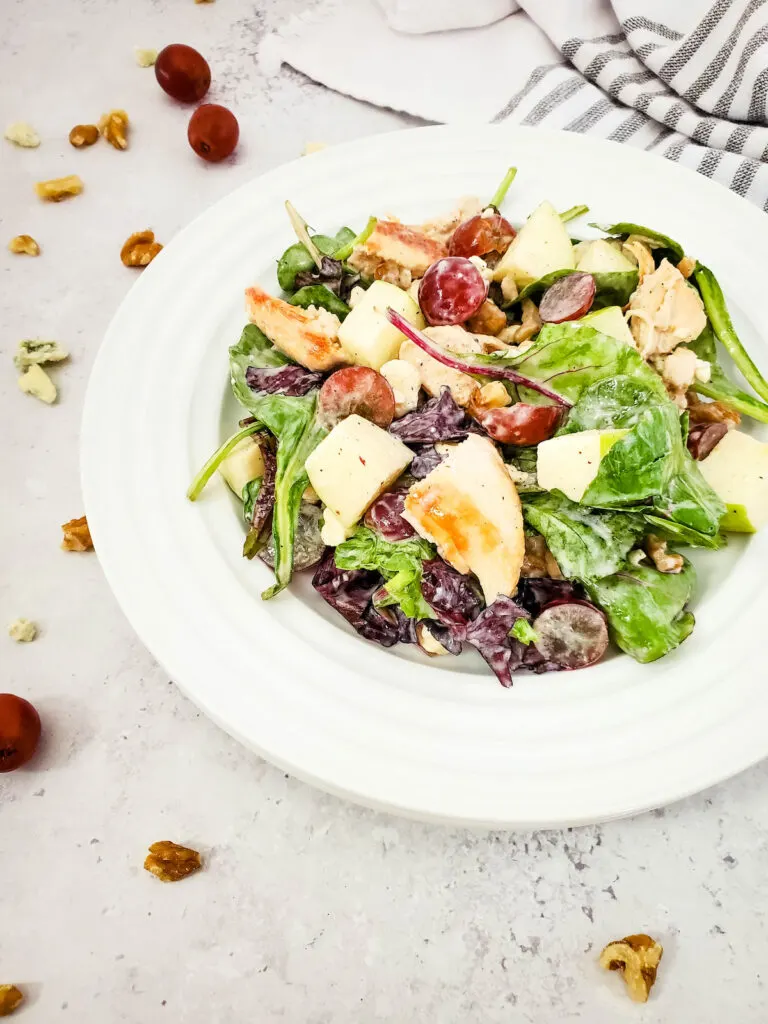 chicken and apple salad on white plate on marble table with fresh ingredients n the side.jpg
