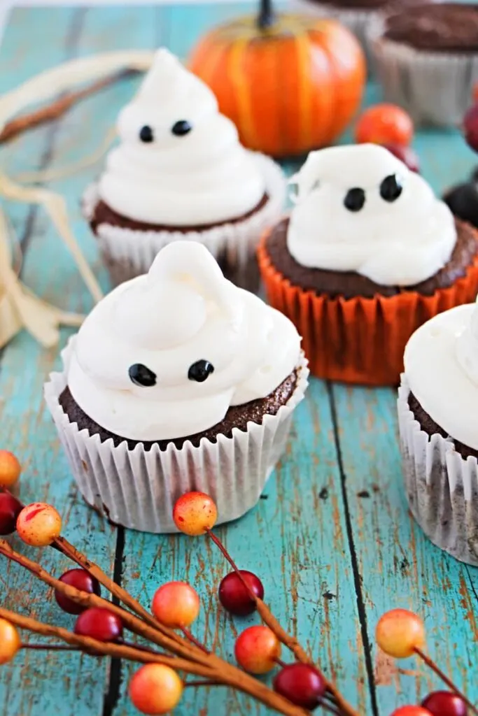 three white ghost cupcake on the old blue table.