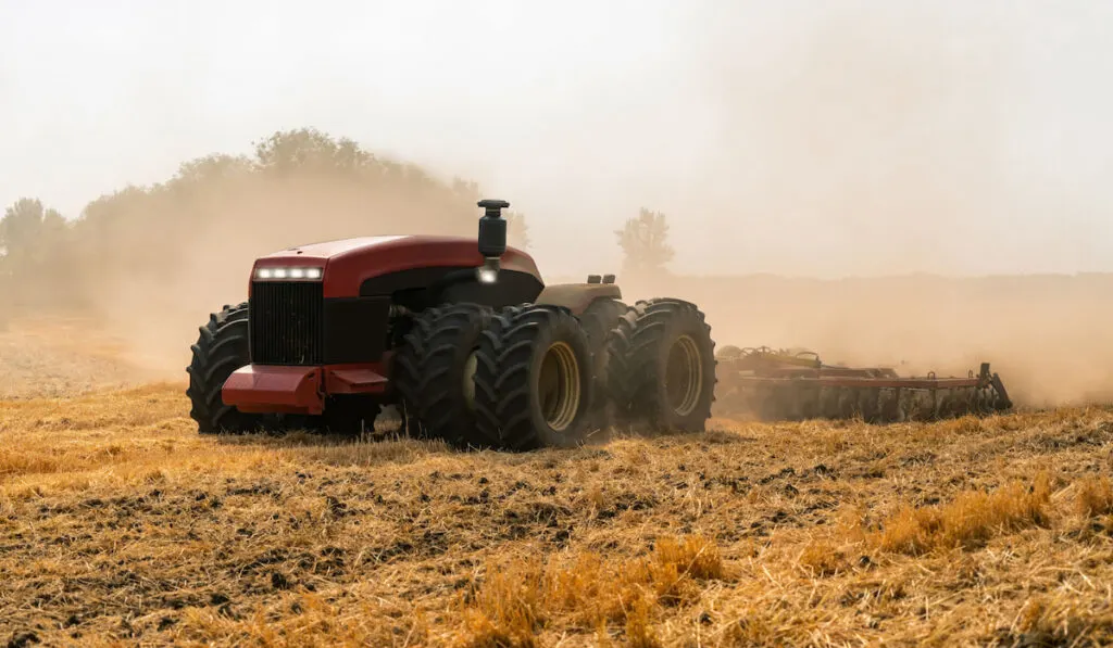 An Autonomous tractor working in the field. Smart farming and digital transformation in agriculture