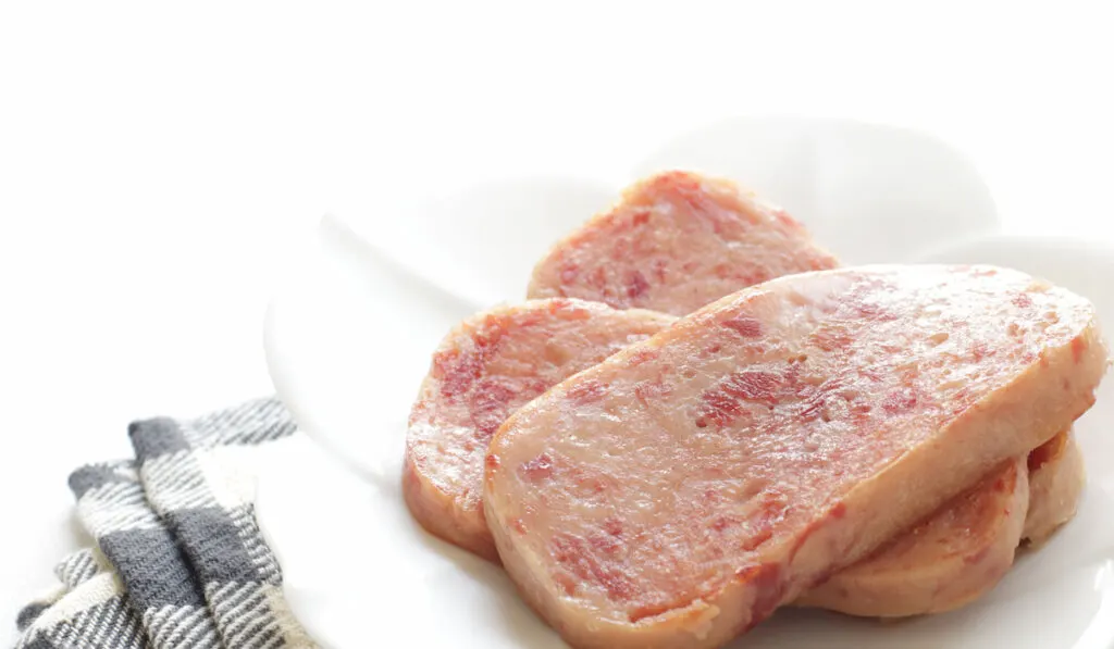 Pan fied Spam dish on white plate on white background