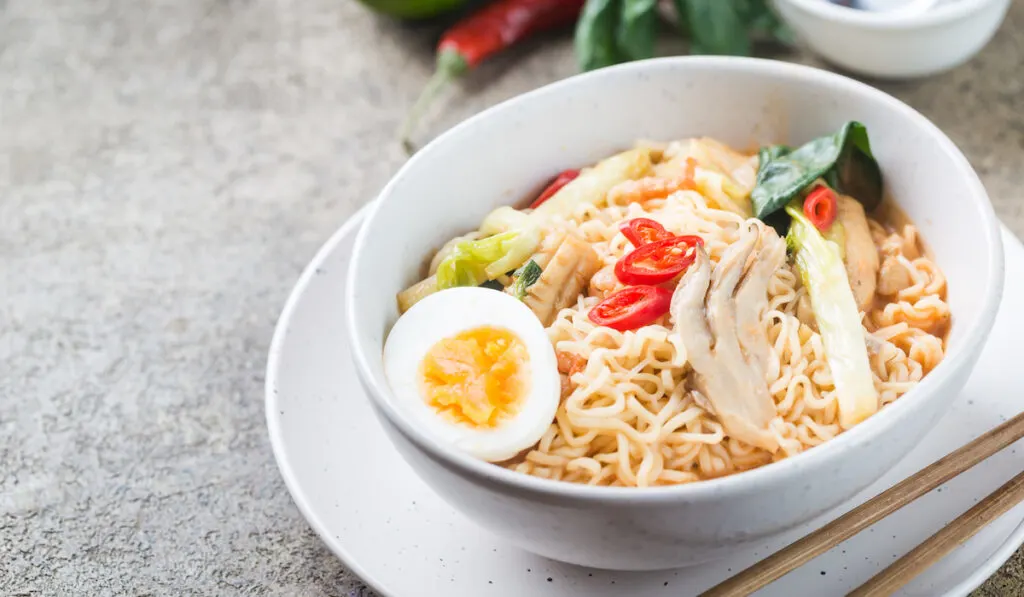 japanese ramen noodle with chicken, shiitake mushroms and egg in white bowl

