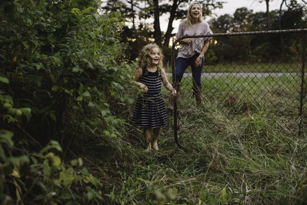 mother and daughter entering the  wired-filled farm gate