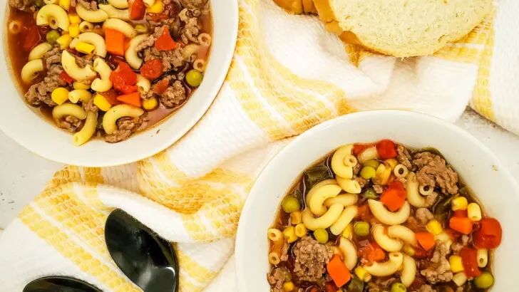 2 bowsl of Crockpot Beef Macaroni Soup laid on table with bread
