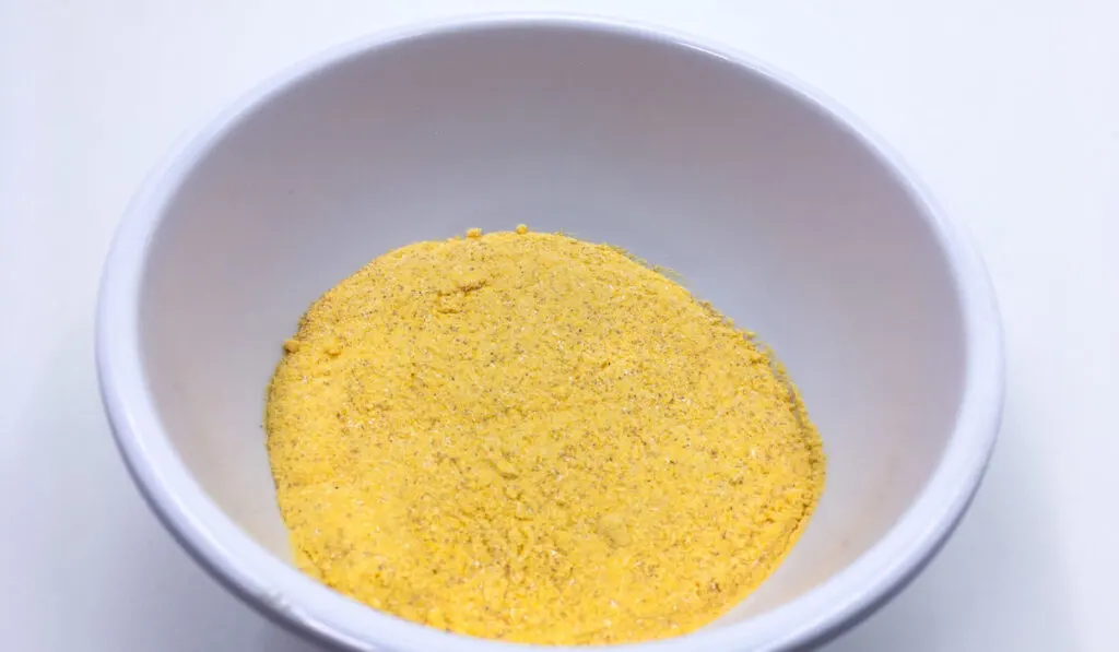 A bowl of the cheese powder on white background.