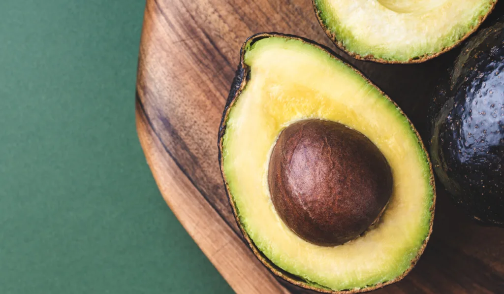 half avocado hass on wooden board