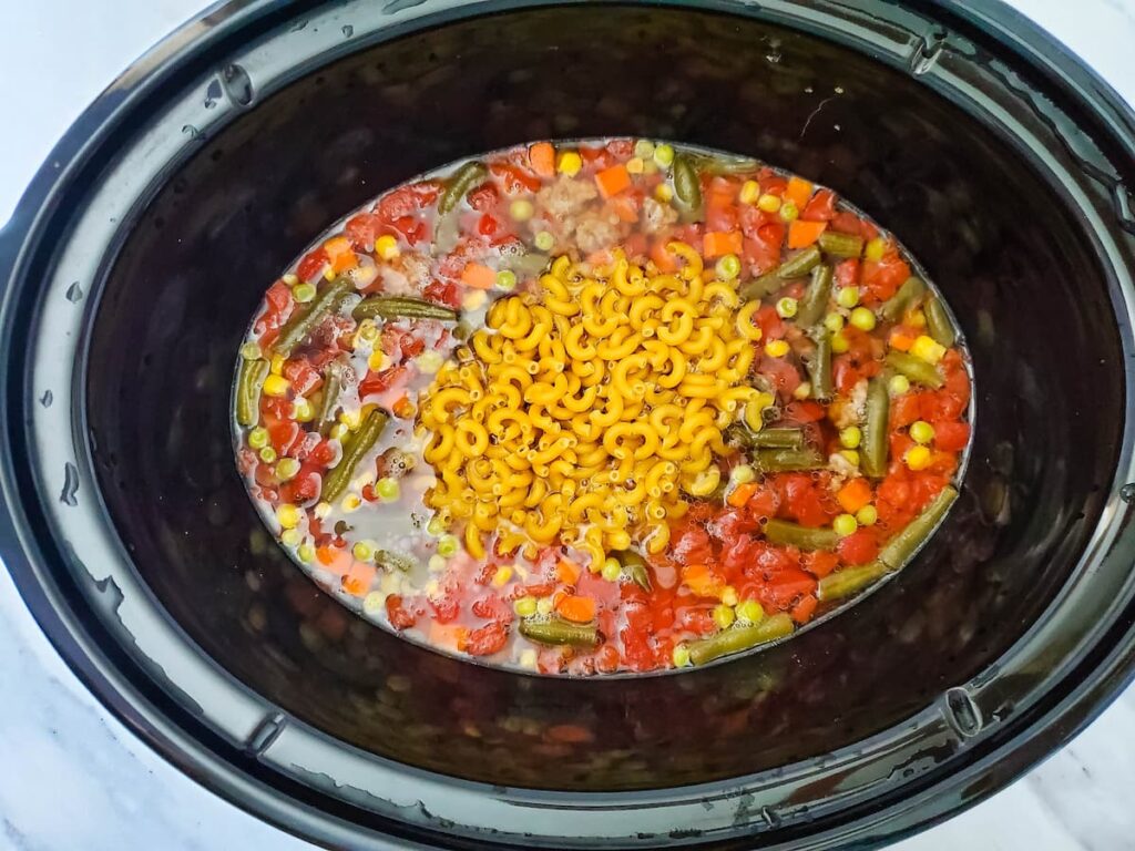 Process 7 noodles added to crockpot with cooked ground beef, mixed veggies, and diced tomatoes