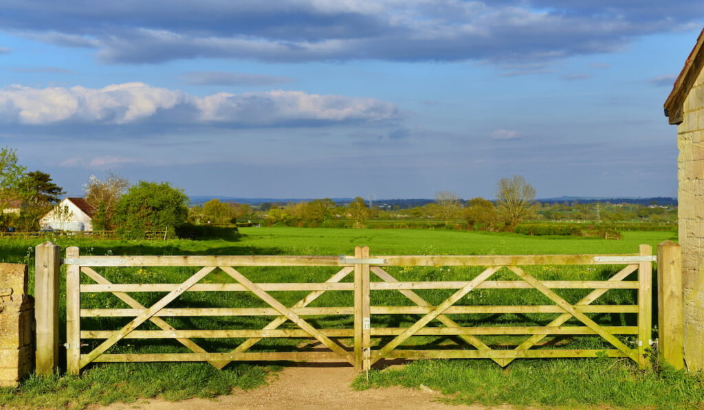 Scenic View of a Farm Gateway and Green Meadow Beyond