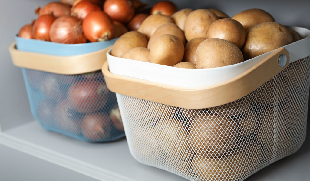 baskets with potatoes and onions on shelf in the kitchen