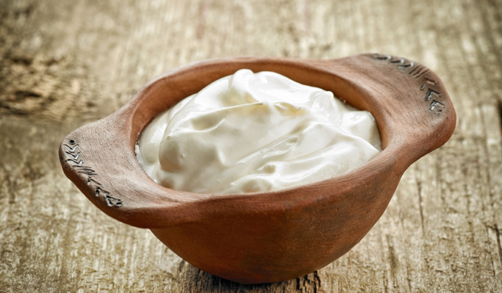 ceramic bowl of sour cream or greek yogurt on wooden table

