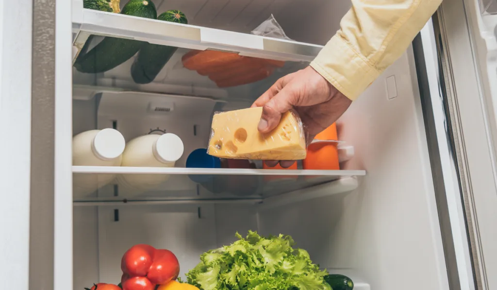 man taking cheese out from fridge