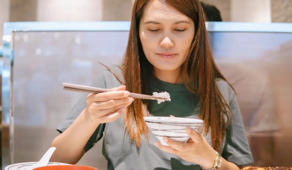 Asian woman eating the rice