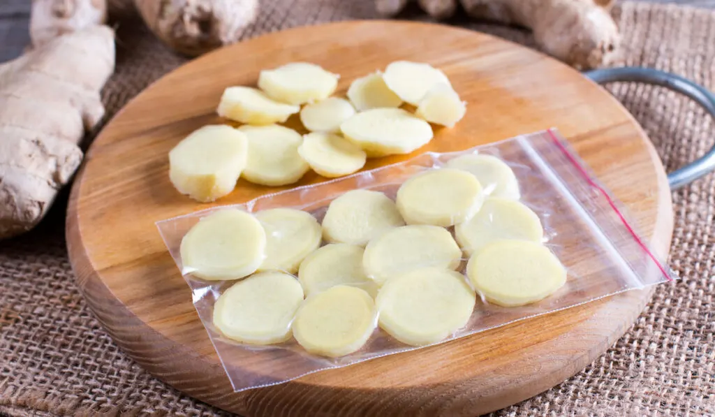 Frozen chopped ginger on wooden board