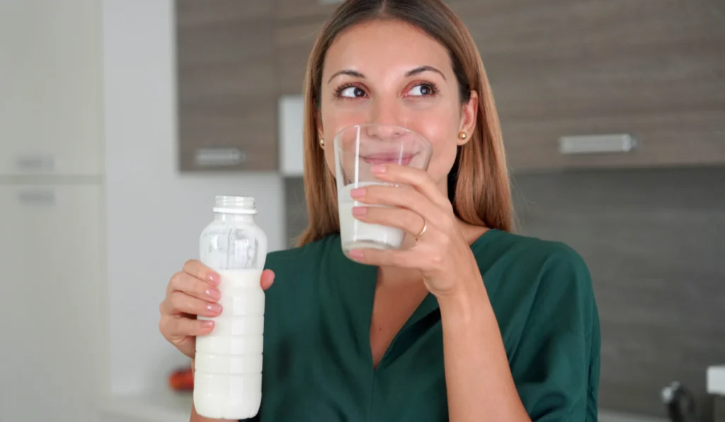 Portrait of young smiling woman drinking 