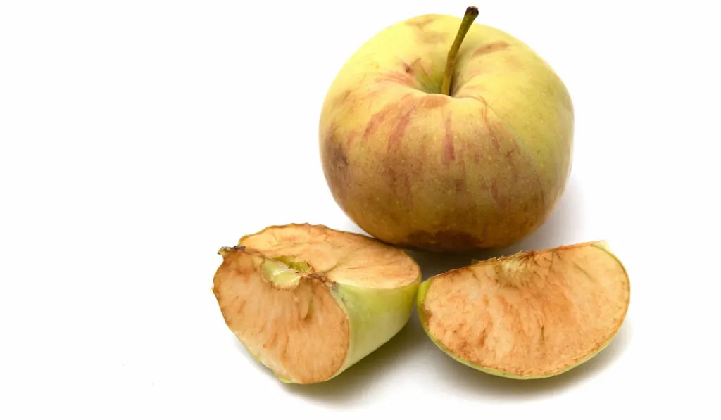 Whole and Slices of an old apple on white background