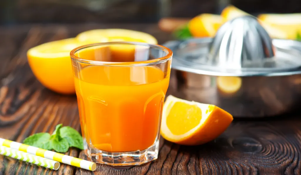 orange juice in glass and fresh fruits


