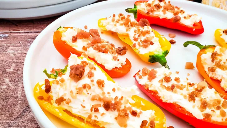 cheesy bacon stuffed mini peppers on white plate on wooden table