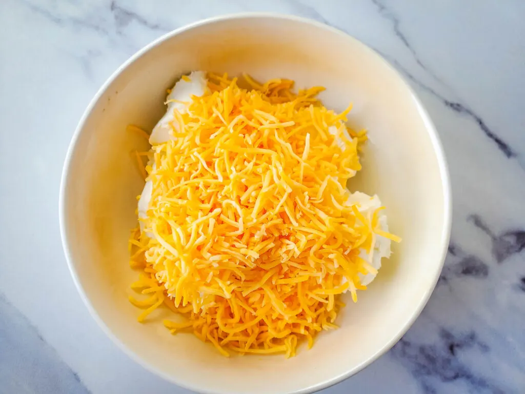 Cream cheese and shredded cheese in a bowl