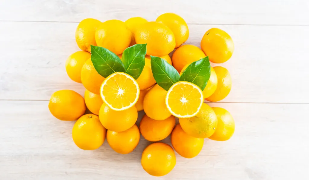 Fresh oranges fruit on white wooden table