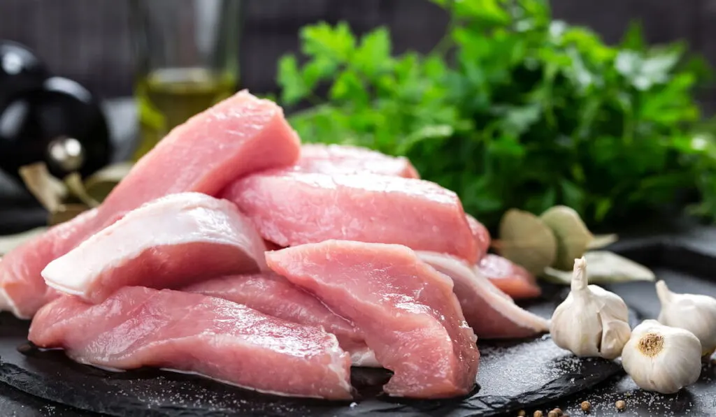 Raw meat on the table kitchen with some herbs and spices for cooking